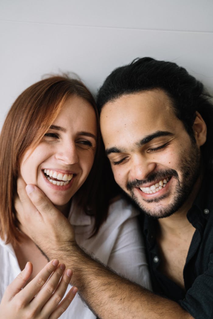 Joyful close-up of a smiling couple embracing each other warmly.